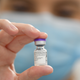 A health care worker in the UK holding up a vial of the Pfizer/BioNTech vaccine